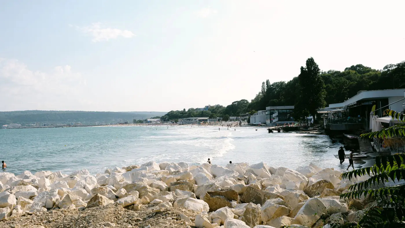 A tranquil beach scene in Bulgaria with clear blue waters and rocky shoreline. Perfect summer travel destination.