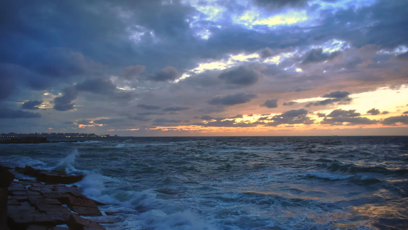 Captivating sunset over the Mediterranean Sea in Alexandria, highlighting clouds, waves, and vibrant skies.