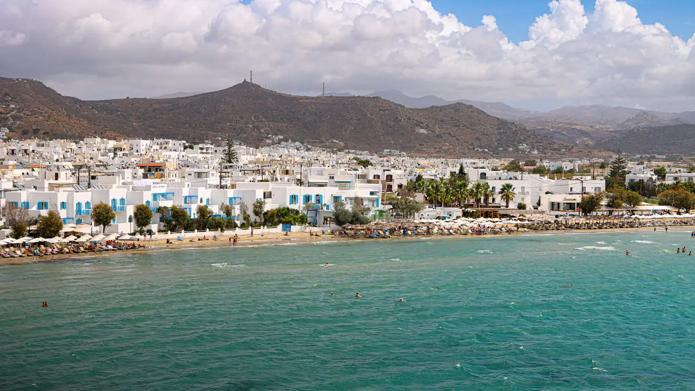 Stunning aerial view of Naxos beach with turquoise waters and white buildings.