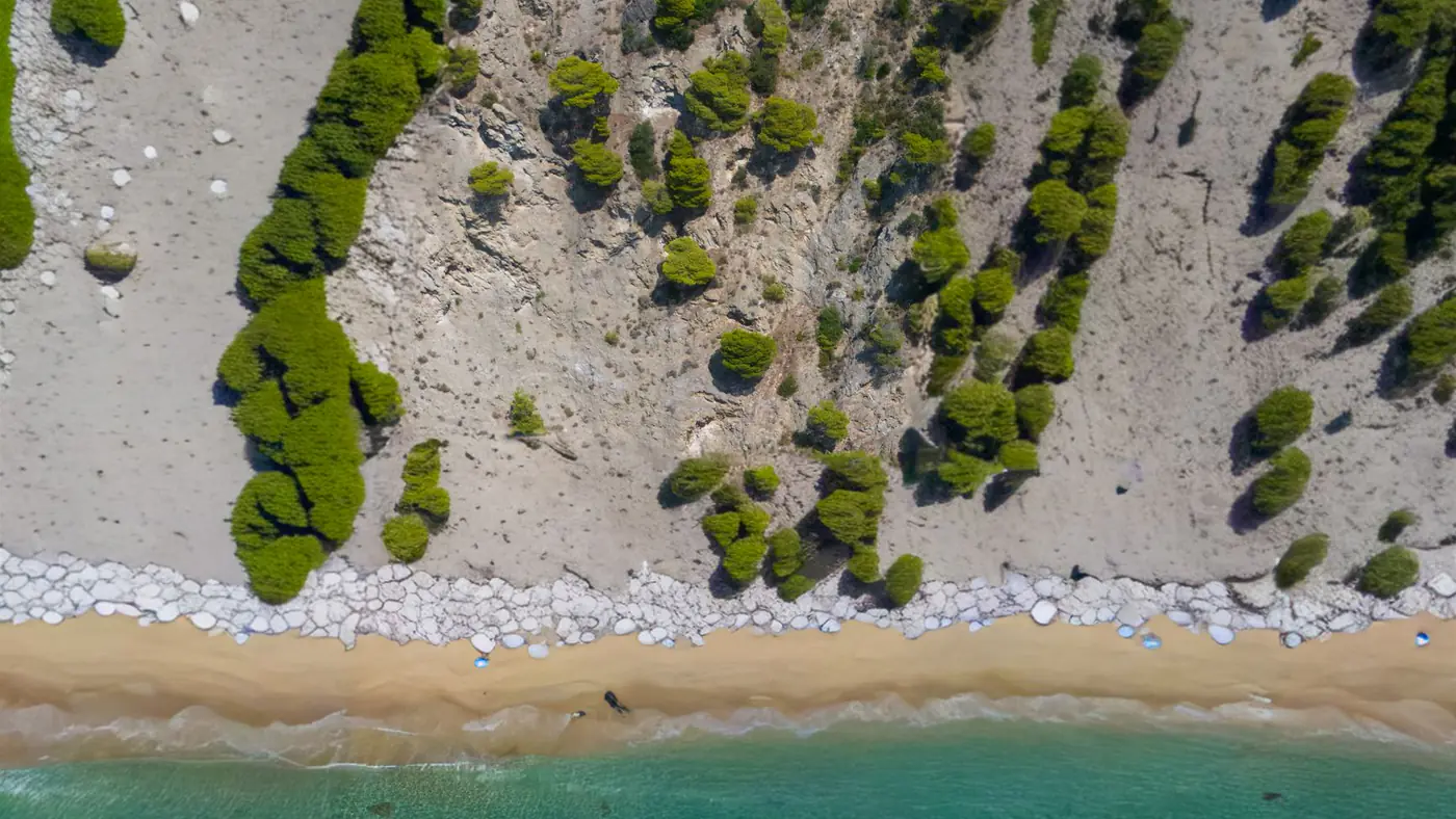 A breathtaking aerial shot of Glyfada Beach in Greece with azure waters and sandy shores.